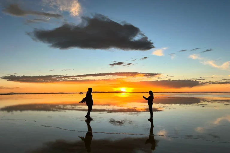 Salar de Uyuni al atardecer, con turistas sacando fotos.